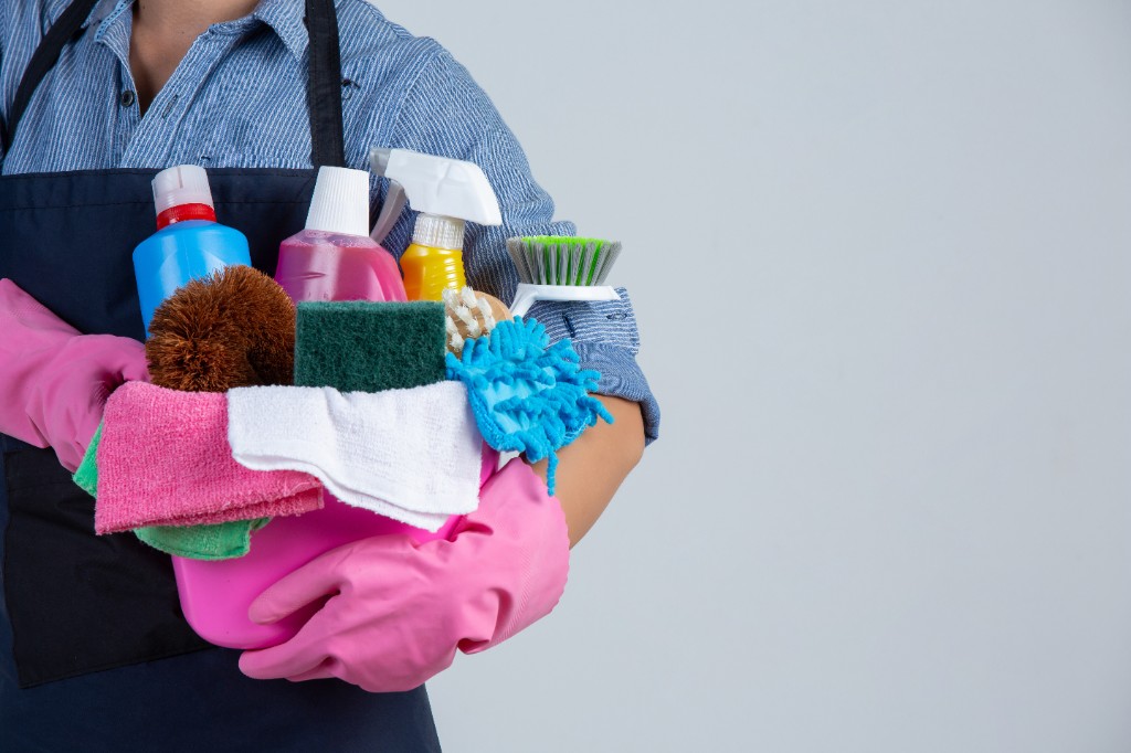 Professional cleaner holding bucket of supplies - space on the right for your headline